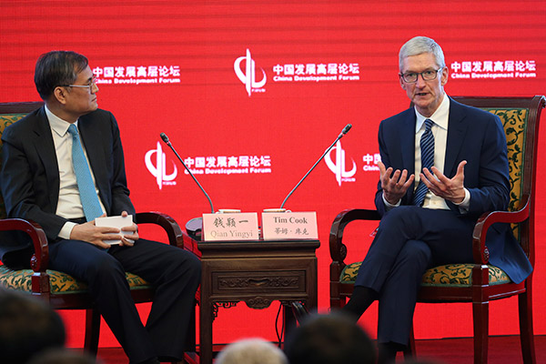 Apple CEO Tim Cook (right) talks with Professor Qian Yingyi, dean of School of Economics and Management, Tsinghua University, during the 18th China Development Forum in Beijing on March 18, 2017. [Photo/China Daily]